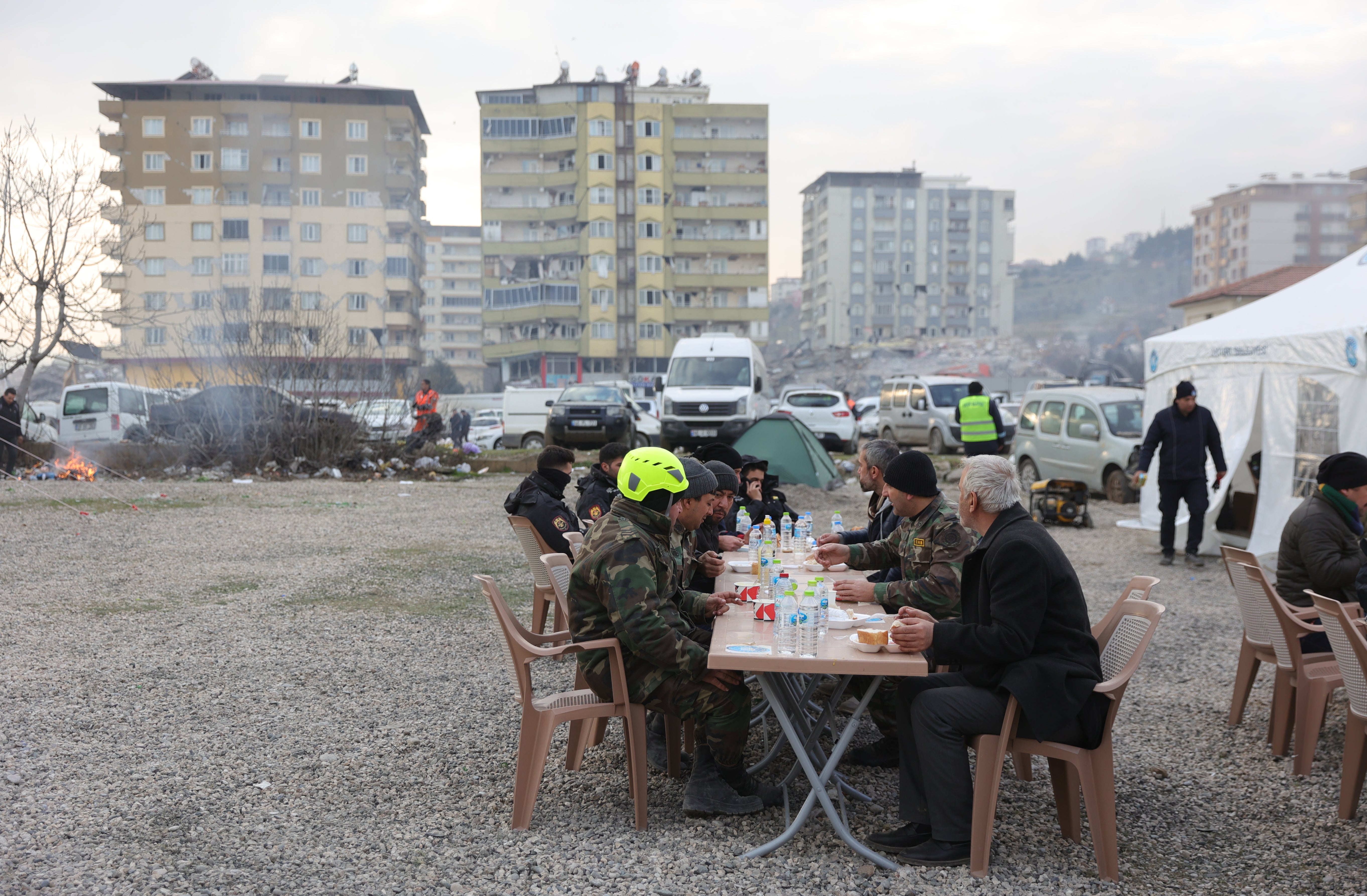 Rescue team members take a break during search for survivors in the city of Kahramanmaras, southeastern Turkey