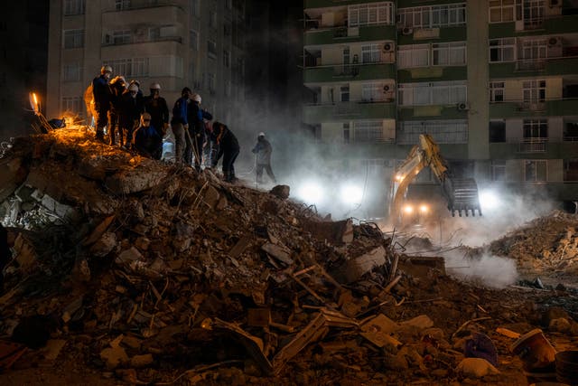 <p>Rescue workers search for bodies and earthquake survivors on a collapsed building in Adana, southeastern Turkey</p>
