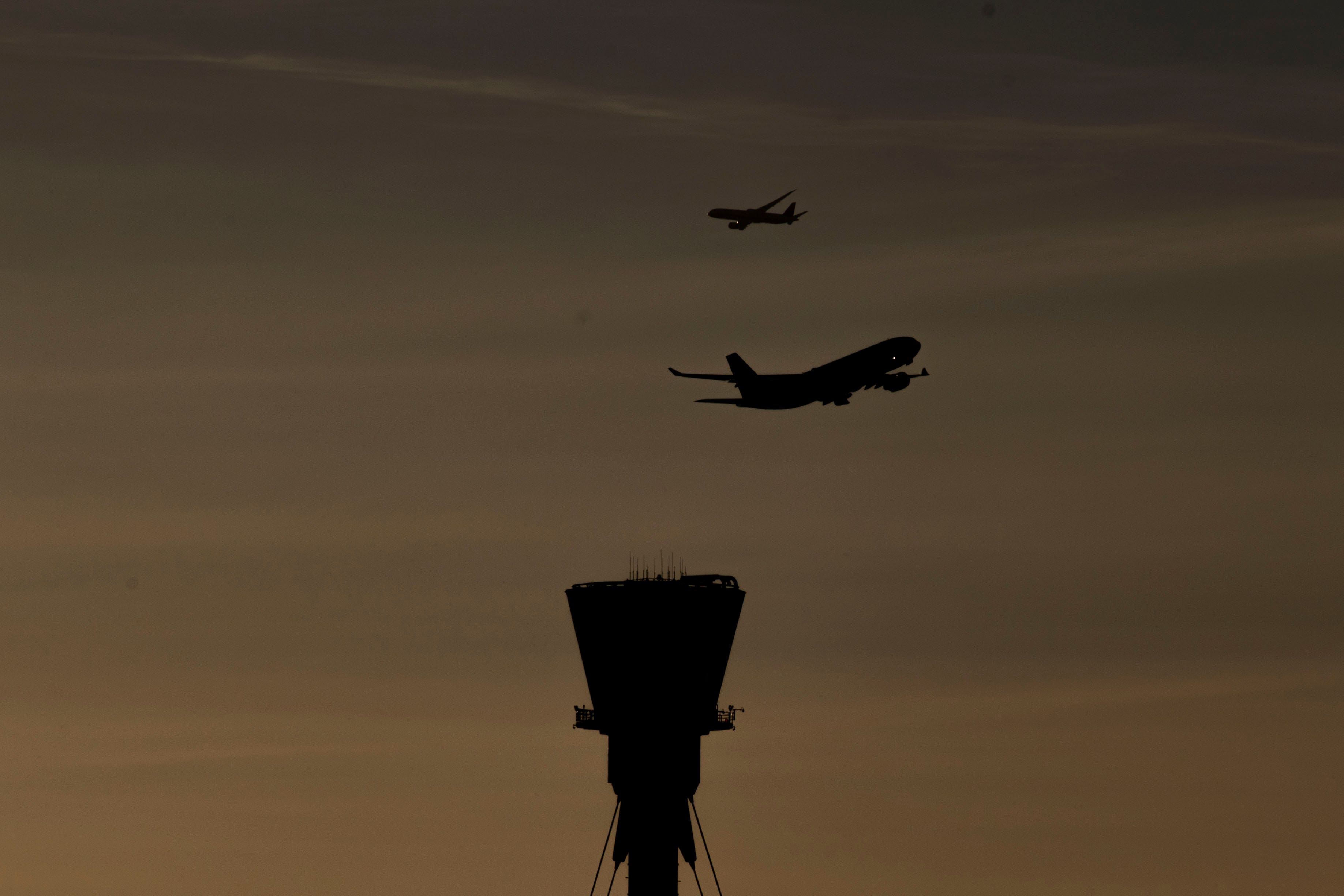 A plane takes off past the control tower at Heathrow (Steve Parsons/PA)