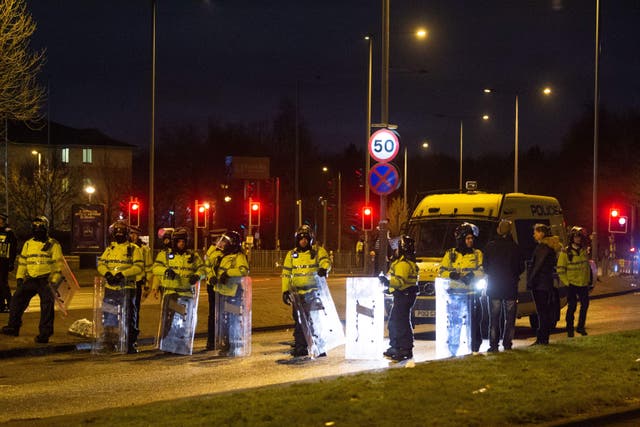 <p>Police in riot gear attending the protest outside the Suites Hotel in Knowsley </p>