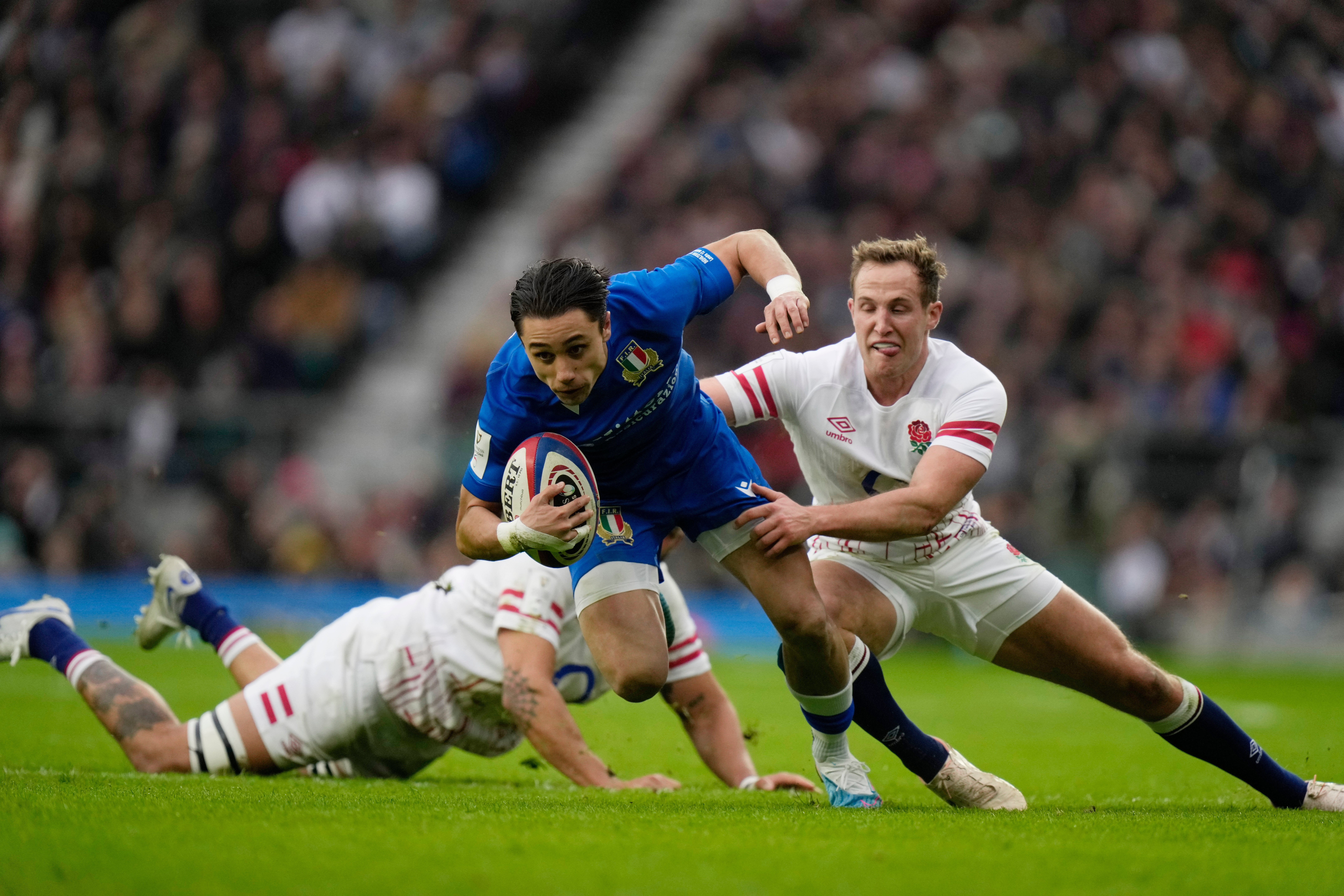 Italy's Ange Capuozzo, centre, tries to avoid being tackled