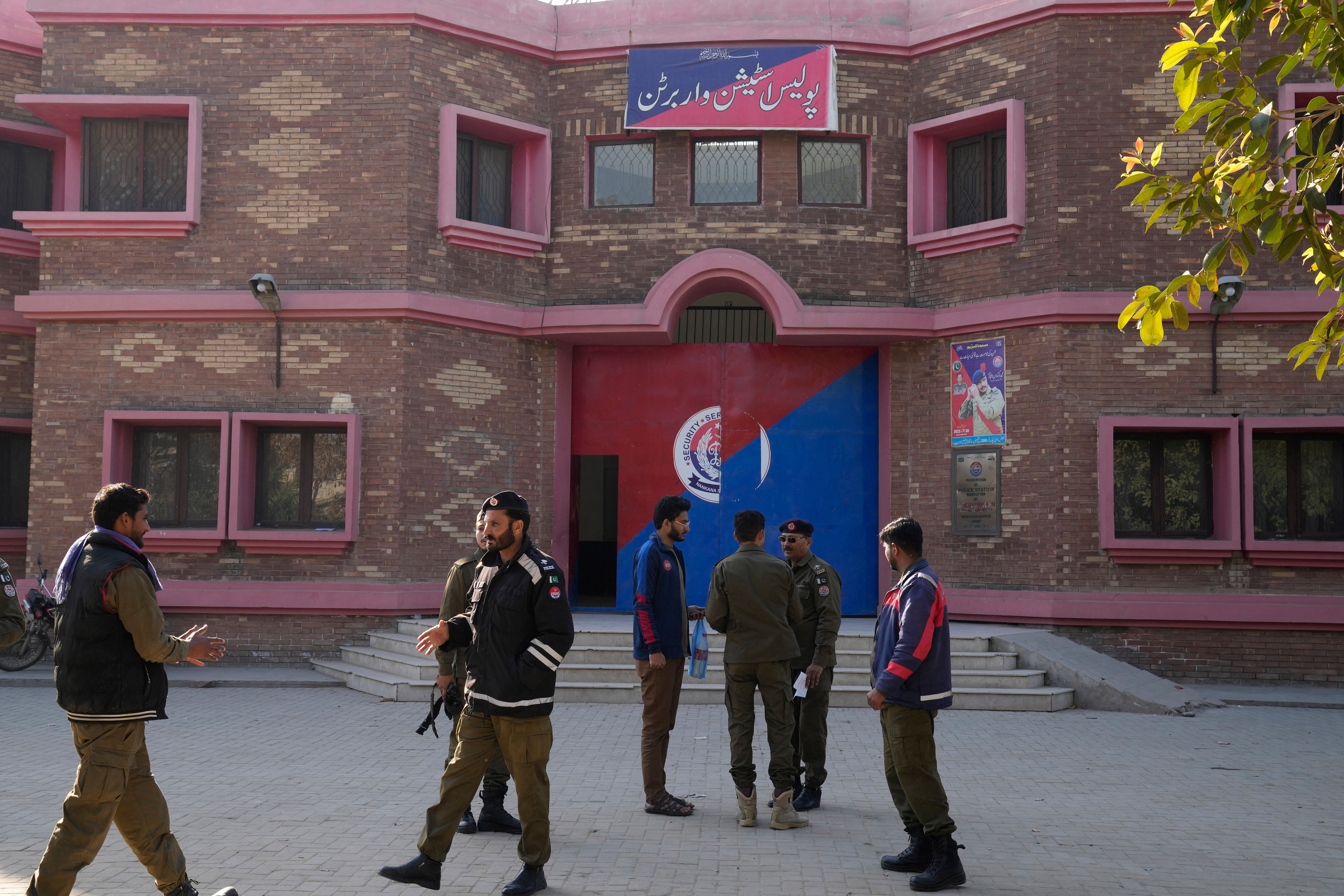 Police officers gather outside a police station in Warburton, an area of district Nankana, on Sunday