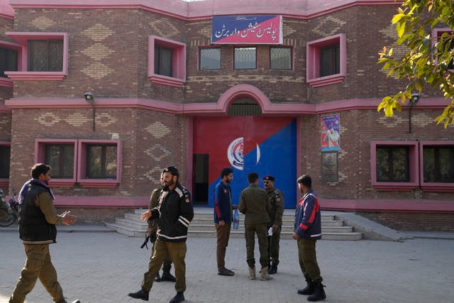 <p>Police officers gather outside a police station in Warburton, an area of district Nankana, on Sunday </p>
