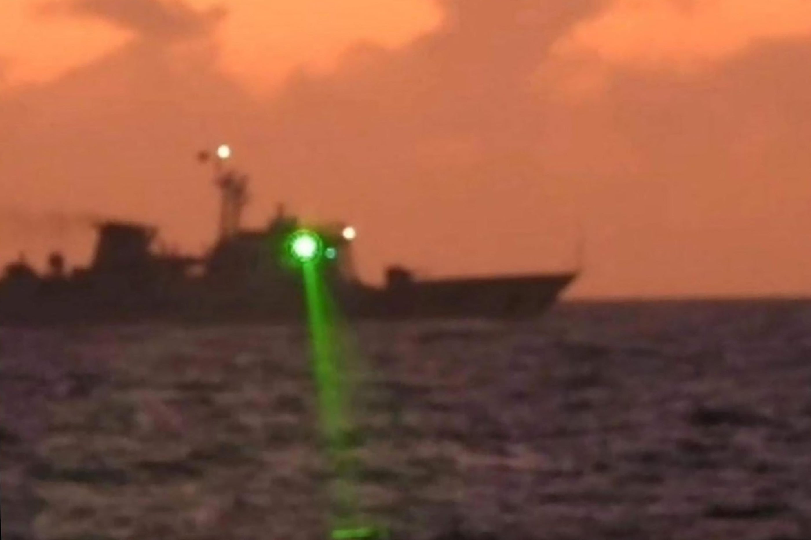 <p>Handout photo shows a Chinese Coast Guard vessel shining a ‘military grade laser light’ at a Philippine Coast Guard boat</p>