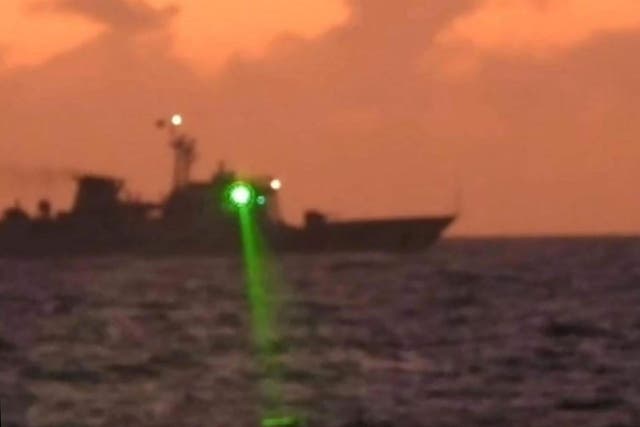 <p>Handout photo shows a Chinese Coast Guard vessel shining a ‘military grade laser light’ at a Philippine Coast Guard boat</p>