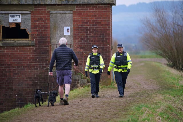 <p>Police officers walk along a footpath in St Michael's on Wyre, Lancashire, as they continue their search for missing woman Nicola Bulley </p>