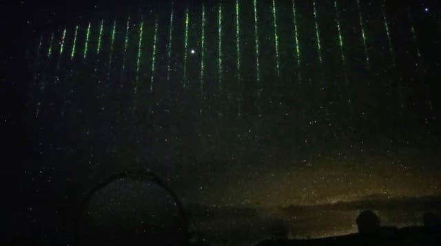 <p>The green laser lights in the cloudy sky over Maunakea, Hawaii, on 28 January</p>