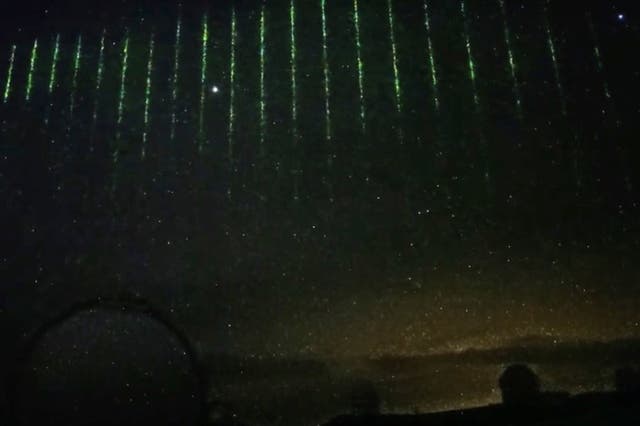<p>The green laser lights in the cloudy sky over Maunakea, Hawaii, on 28 January</p>