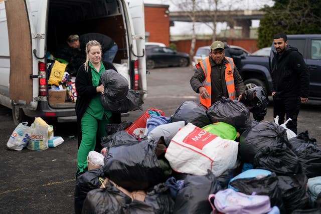 Melodie Aslan, her father Michael Denigin, and Bearded Broz charity volunteers, at a drop-off for earthquake relief donations in Smethwick, West Midlands. (Jacob King/PA)