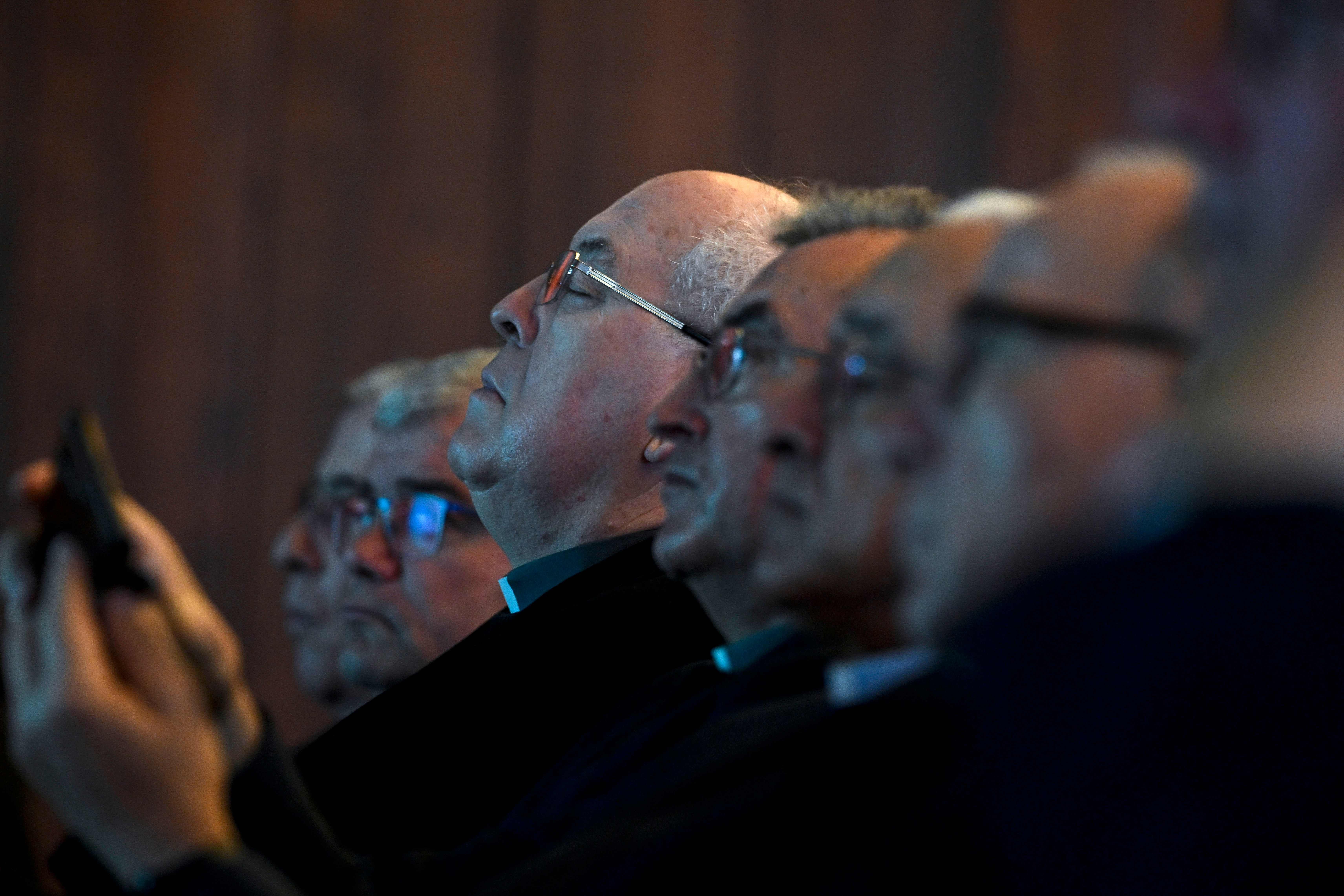 Priests listen to the findings of the independent commission at a press conference in Lisbon on Monday