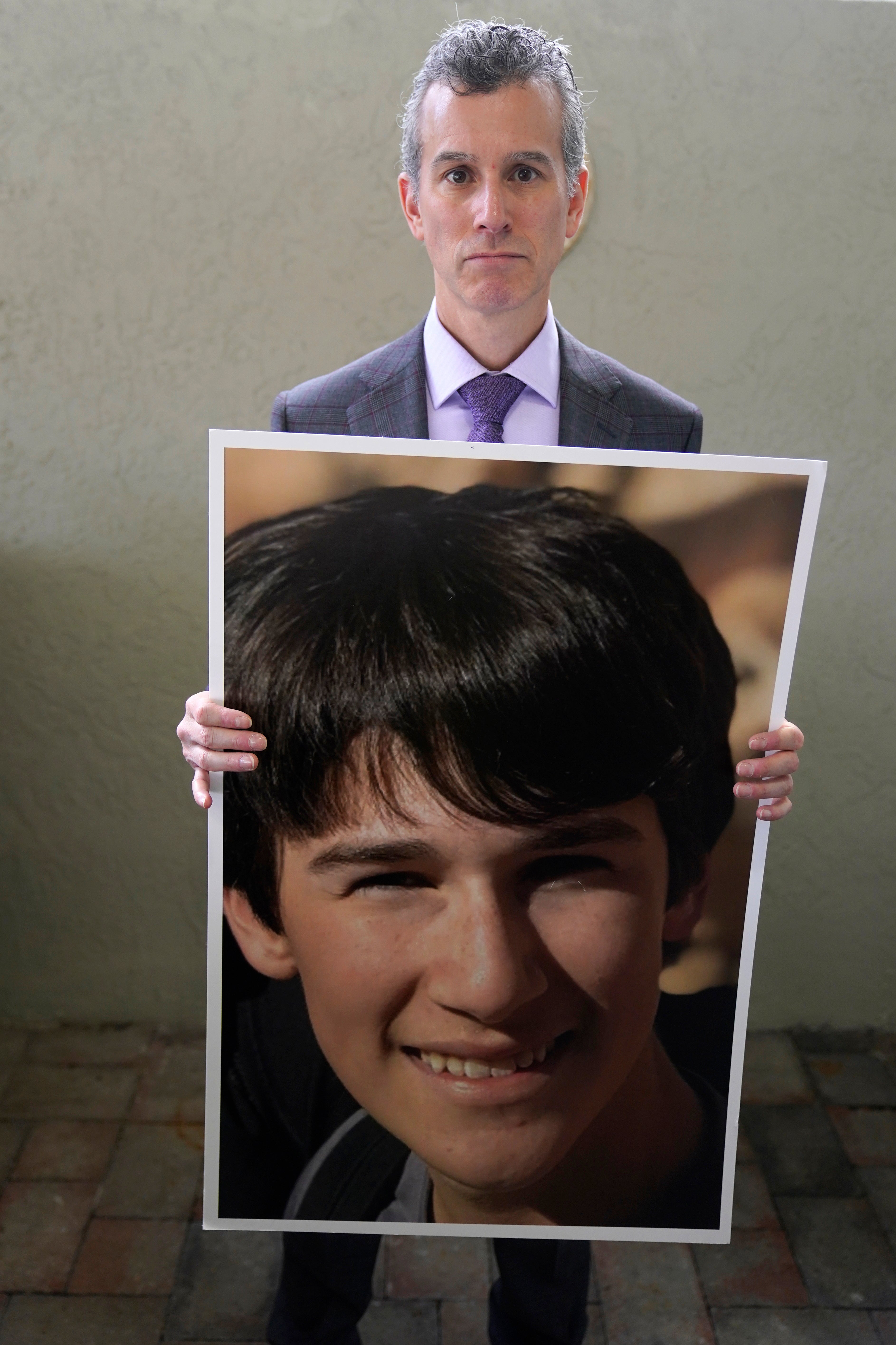 Max Schachter holds a photo of his son, Alex, during an interview, Monday, Jan. 30, 2023