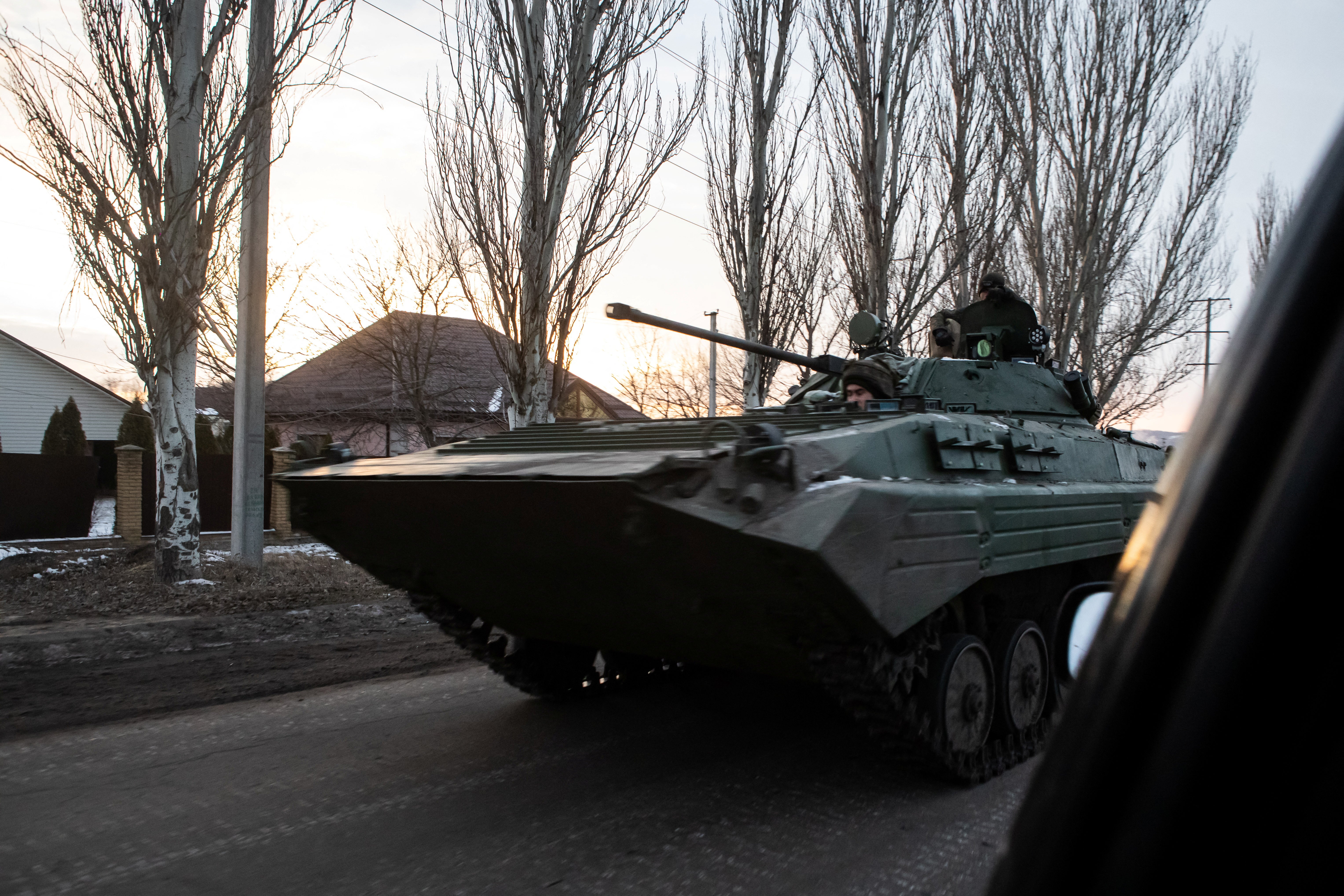 Ukrainian servicemen drive along a street with BMP-2 infantry fighting vehicle in the frontline town of Bakhmut in February 2023