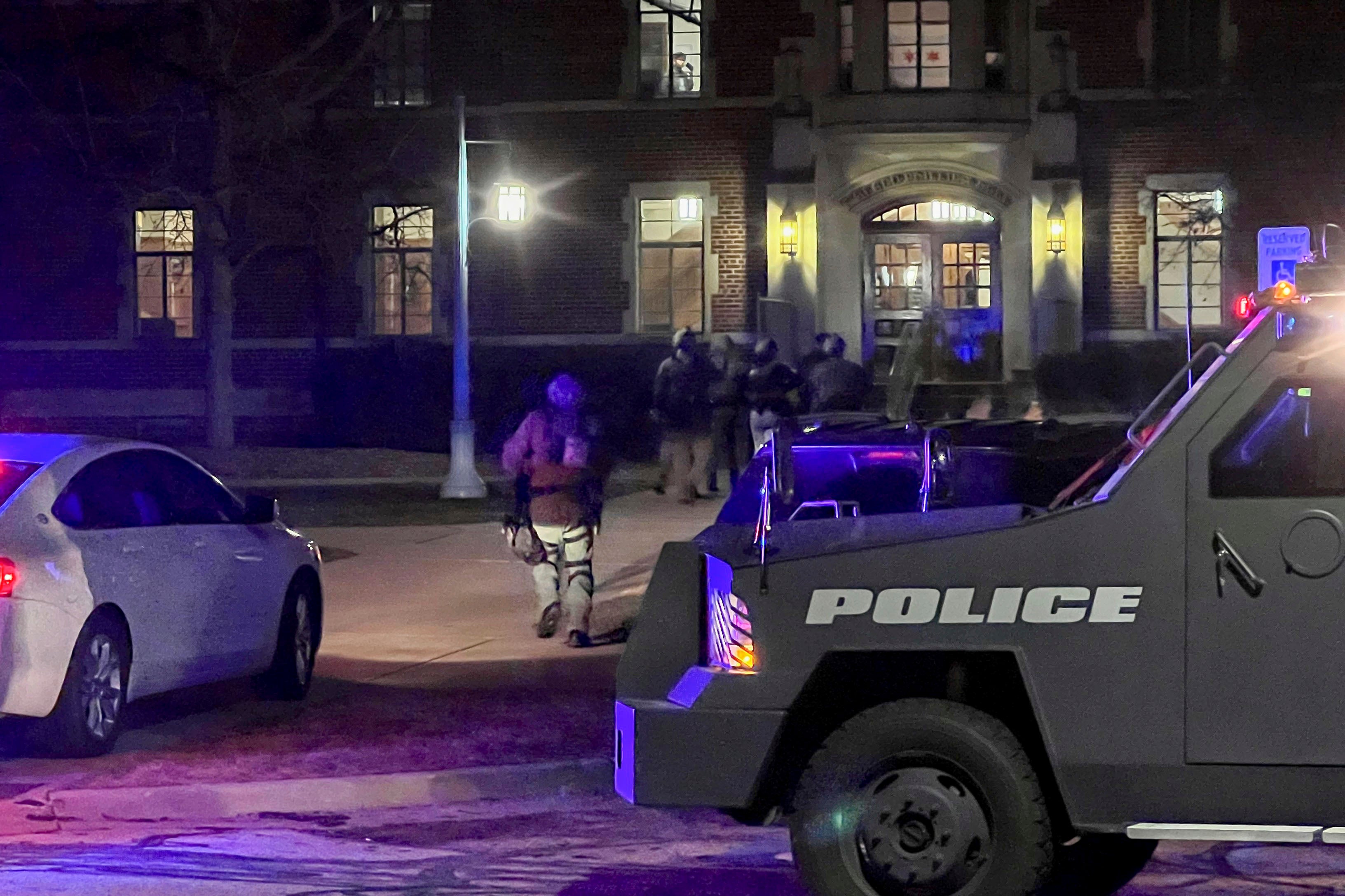 Armed police officers with weapons drawn rush into Phillips Hall on the campus of Michigan State University, in East Lansing, Michigan