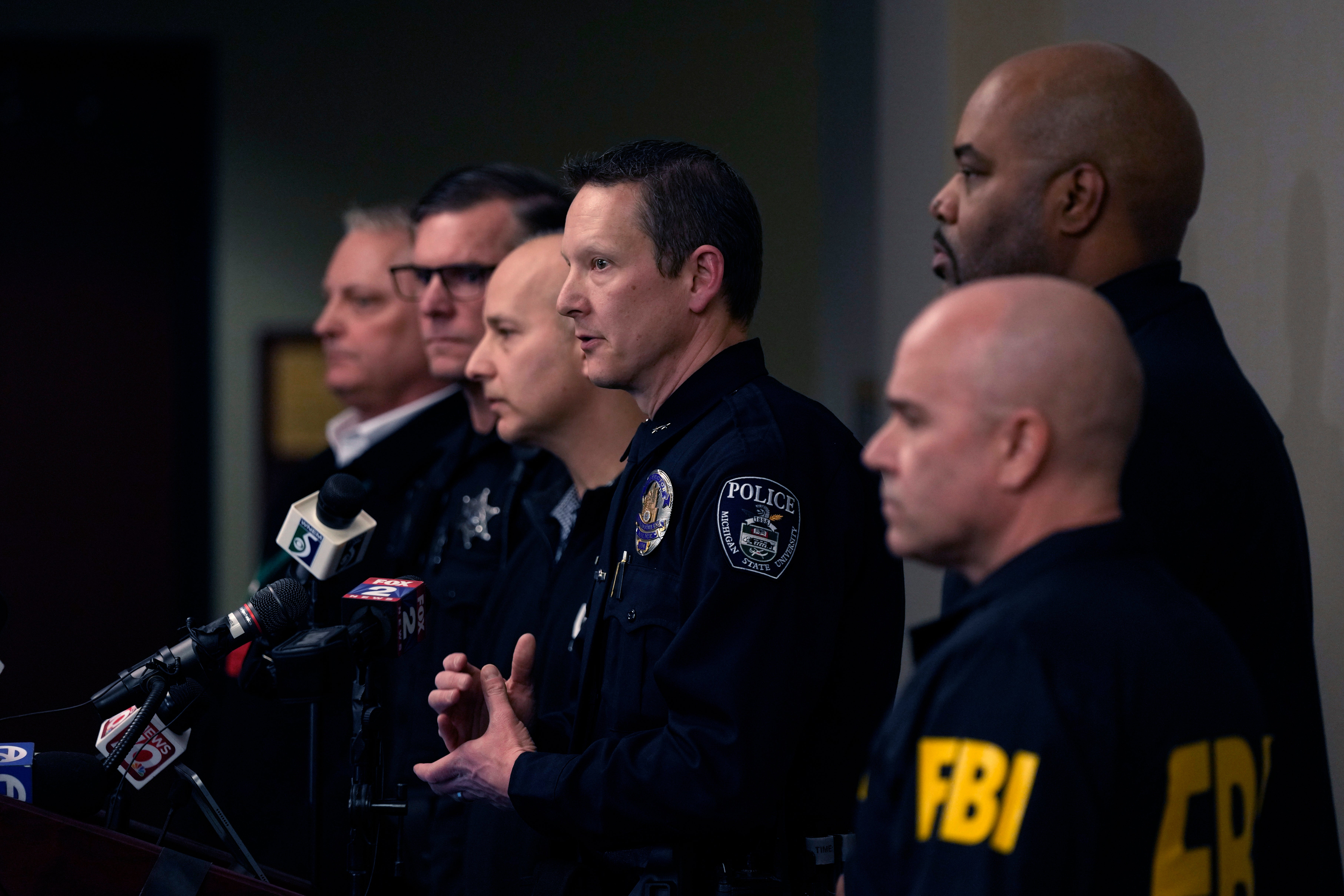 Michigan State University interim deputy police chief Chris Rozman, center, joins law enforcement officials while addressing the media, Tuesday, 14 February2023
