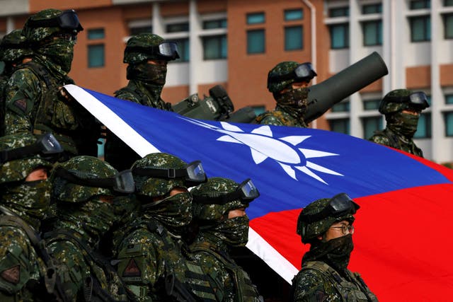 <p> Taiwan’s armed forces pose for a photo with the Taiwanese flag during a routine drill</p>