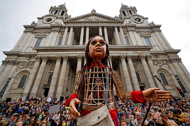 <p>‘Little Amal’, a giant puppet depicting a Syrian refugee girl, is surrounded by well-wishers outside St Paul’s Cathedral in the City of London</p>