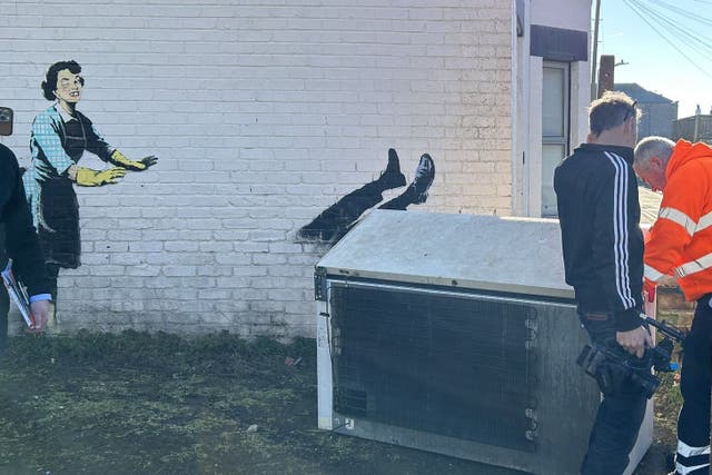 People wearing hi-vis workwear in Margate removing a chest freezer which formed part of a new artwork by Banksy (@danbamhiggins/PA)