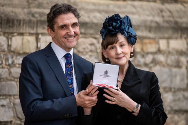 Mrs Heidi-Louise Thomas McGann, screenwriter and playwright, from Royston, with her husband Stephen McGann after being made an Officer of the Order of the British Empire by the King at Windsor Castle (Aaron Chown/PA)