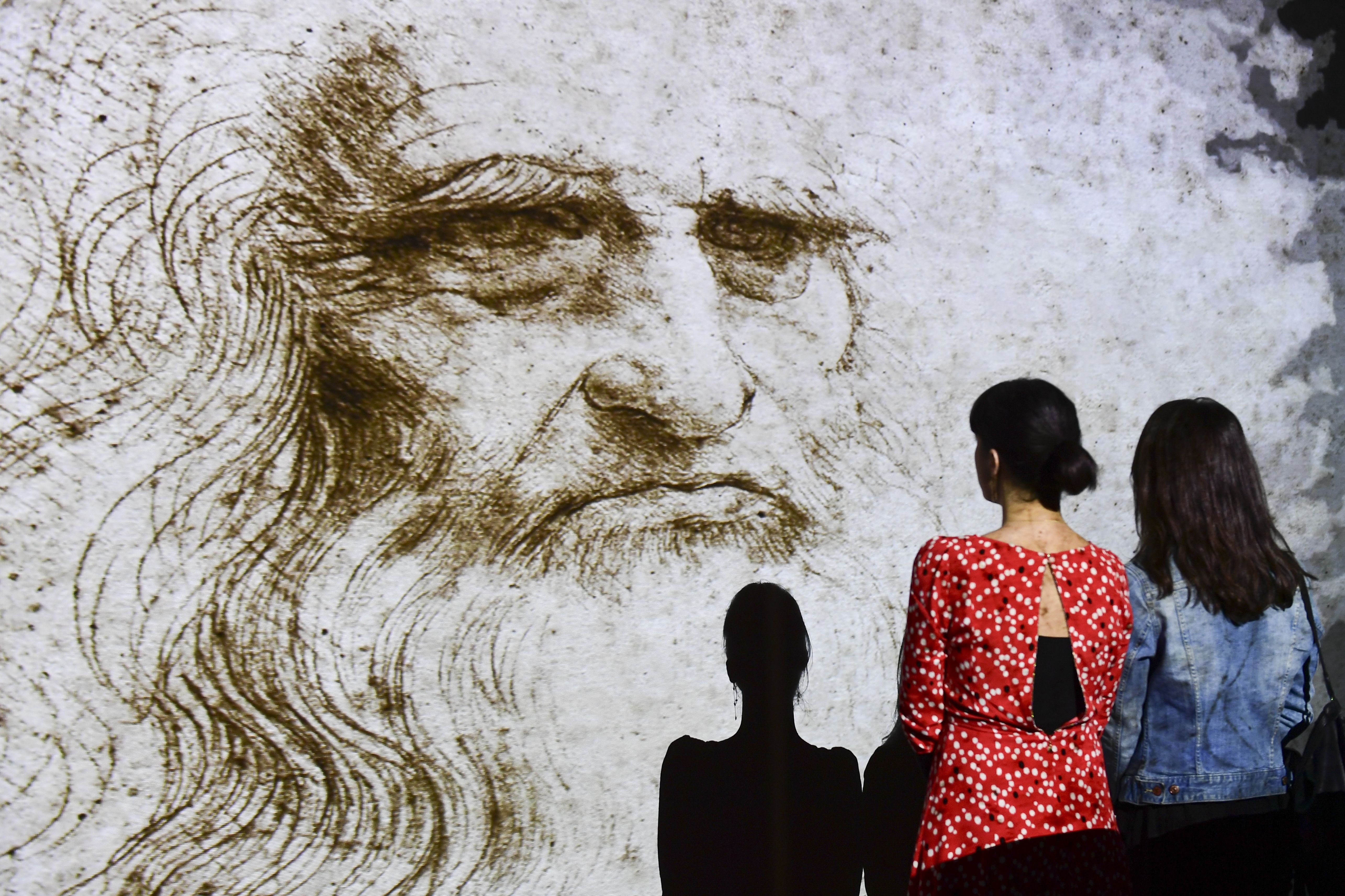 People watch a hologram called ‘Studio di uomo barbuto’ (study of bearded man) during the Leonardo da Vinci multimedia installation ‘Leonardo Da Vinci 3D’ at the Fabbrica del Vapore (Steam Factory) in Milan, on 29 May 2019