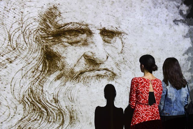 <p>People watch a hologram called ‘Studio di uomo barbuto’ (study of bearded man) during the Leonardo da Vinci multimedia installation ‘Leonardo Da Vinci 3D’ at the Fabbrica del Vapore (Steam Factory) in Milan, on 29 May 2019</p>