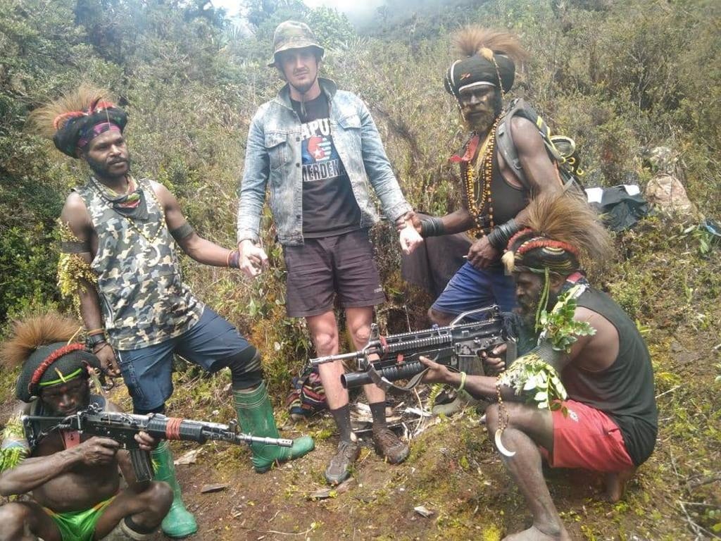 <p>A man, identified as Philip Mehrtens, the New Zealand pilot who is said to be held hostage by a pro-independence group, stands among the separatist fighters in Indonesia's Papua region</p>