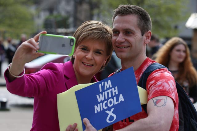 SNP leader Nicola Sturgeon takes a picture with a party supporter during a walkabout in Edinburgh, following the SNP winning a third victory in the Scottish Parliament election in 2016 (Andrew Milligan/PA)