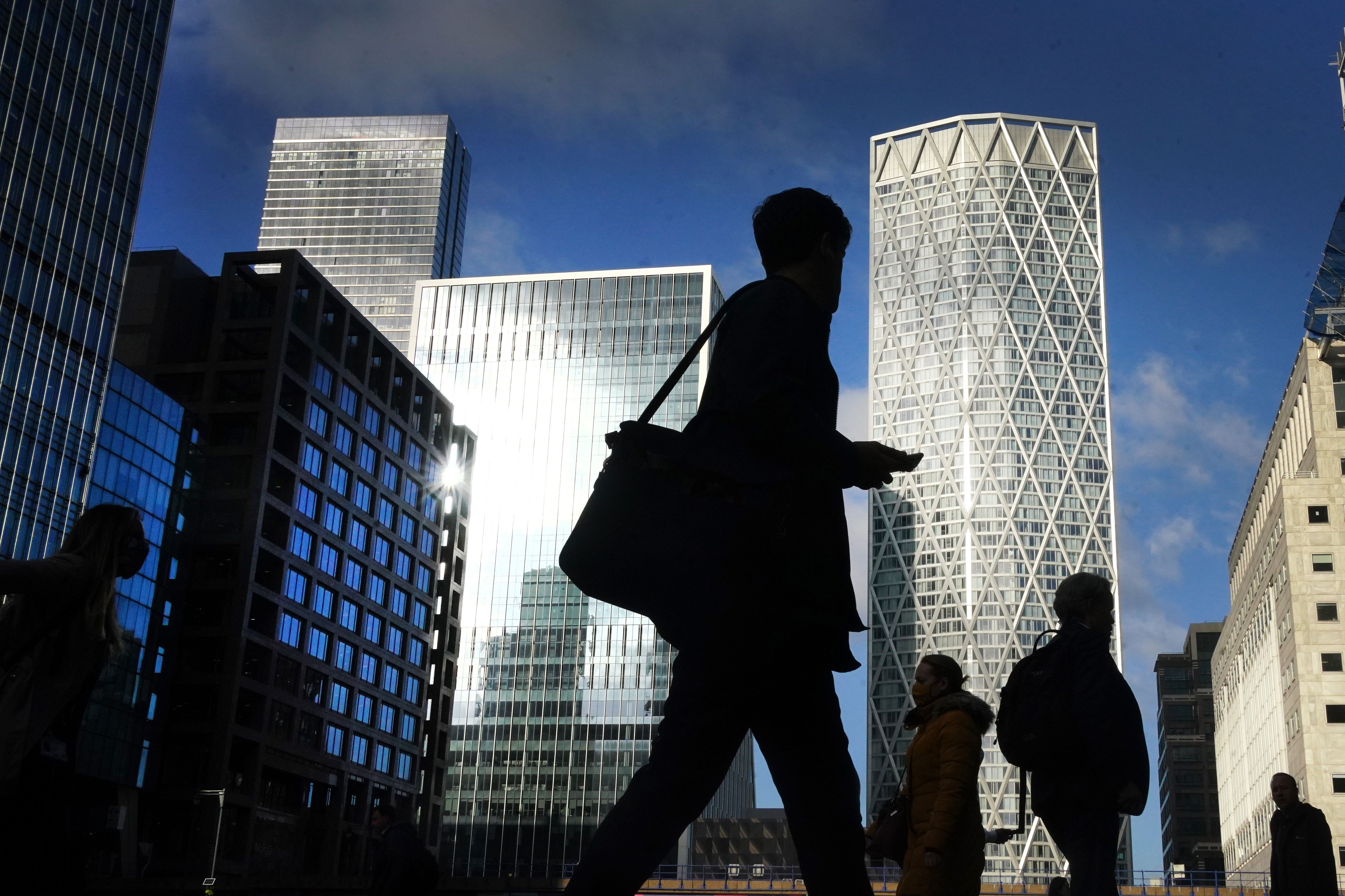 Office workers and commuters walk through Canary Wharf in London (Victoria Jones/PA)