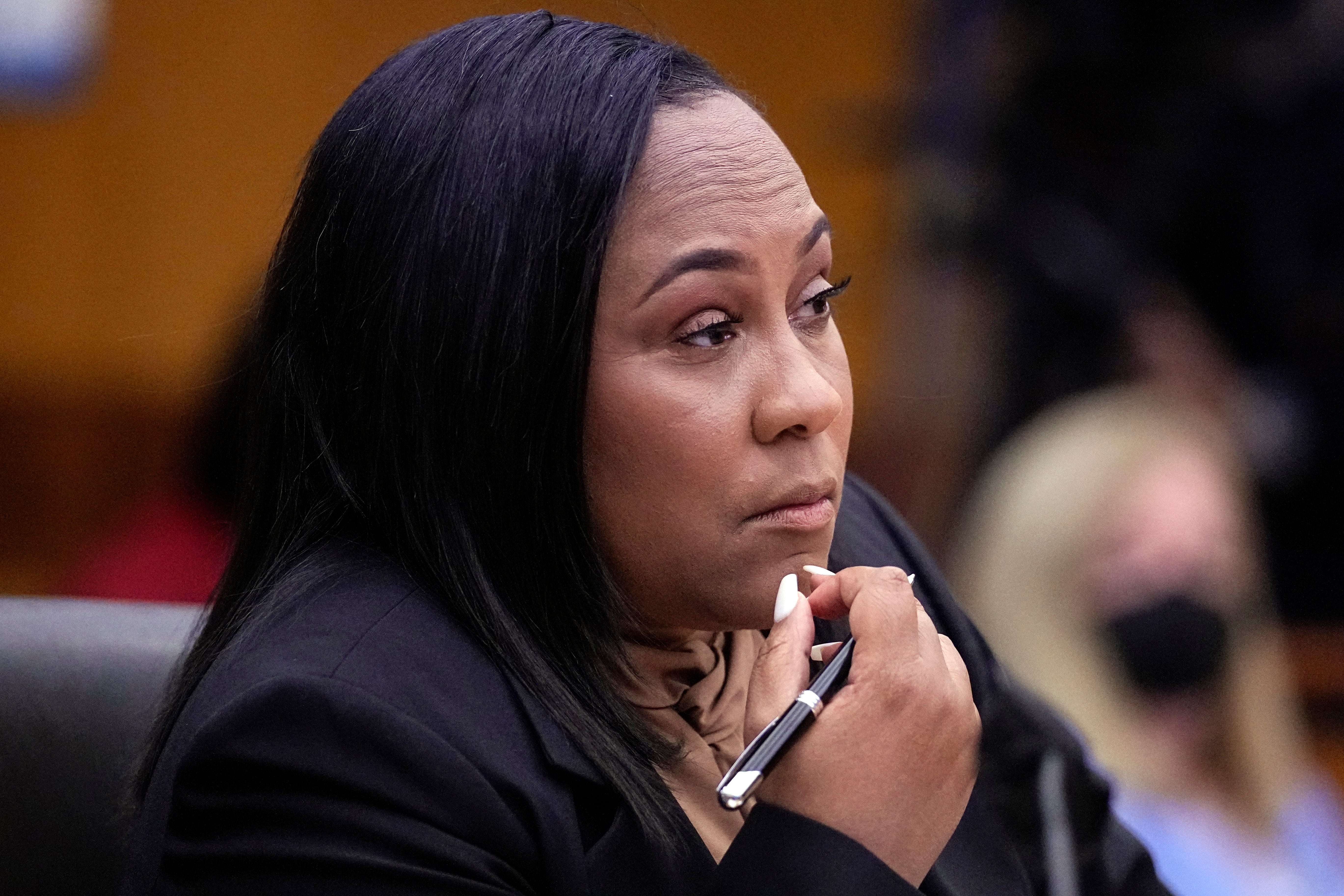 Fulton County District Attorney Fani Willis watches proceedings during a hearing to decide if the final report by a special grand jury looking into possible interference in the 2020 presidential election
