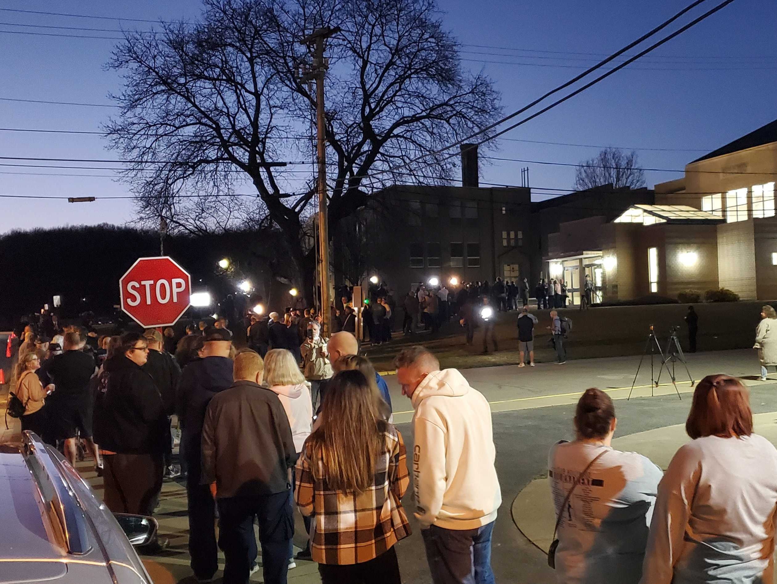 A line of East Palestine residents wait in a line outside the village’s high school, hoping for answers in the wake of a Norfolk Southern train derailment