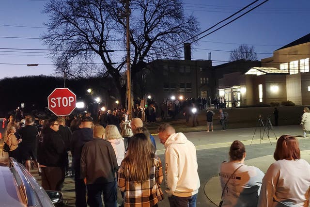 <p>A line of East Palestine residents wait in a line outside the village’s high school, hoping for answers in the wake of a Norfolk Southern train derailment</p>