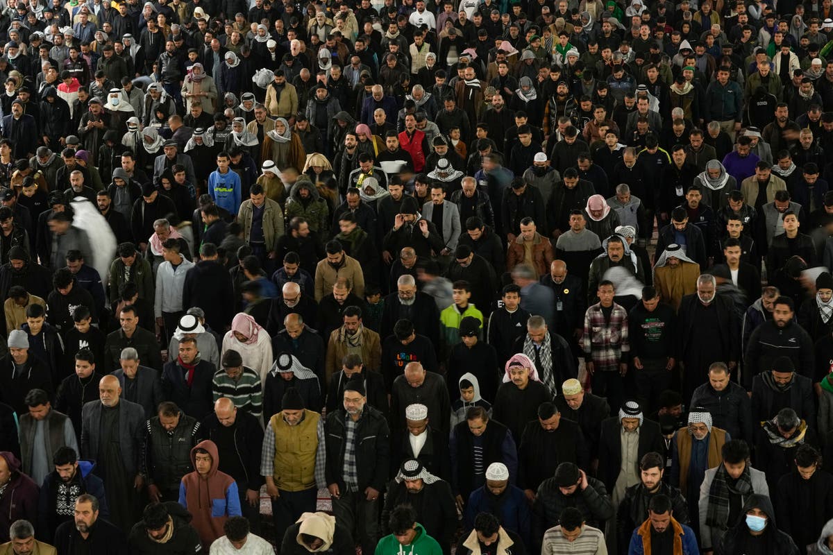 Shiite pilgrims march through Baghdad surrounded by security