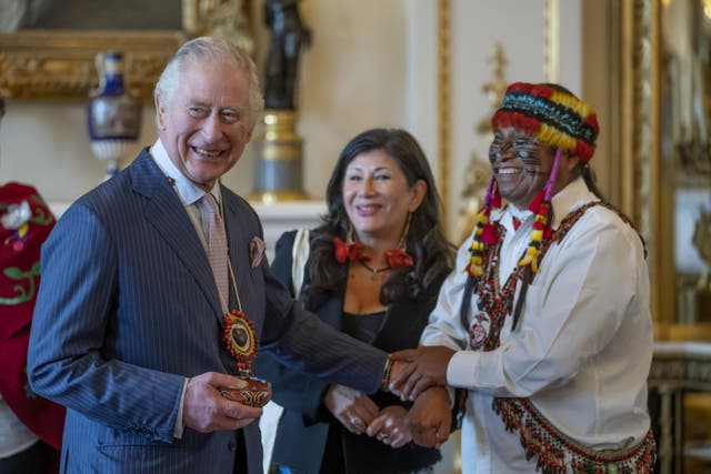 Amazon Indigenous leader Domingo Peas presents a gift to King Charles at Buckingham Palace (Kin Cheung/PA)