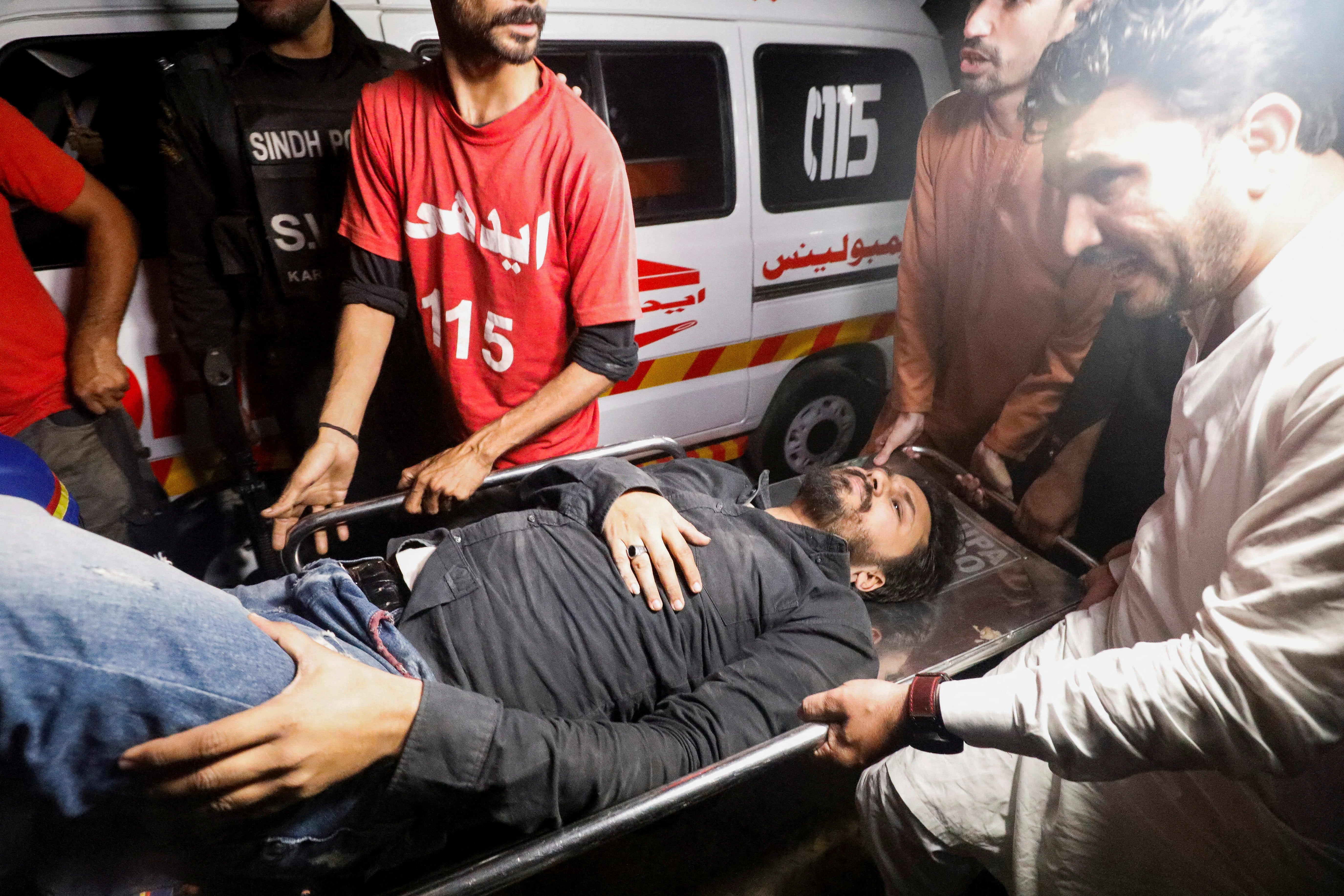 Rescue workers carry an injured person after the attack in Karachi