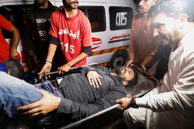 <p>Rescue workers carry an injured person after the attack in Karachi</p>
