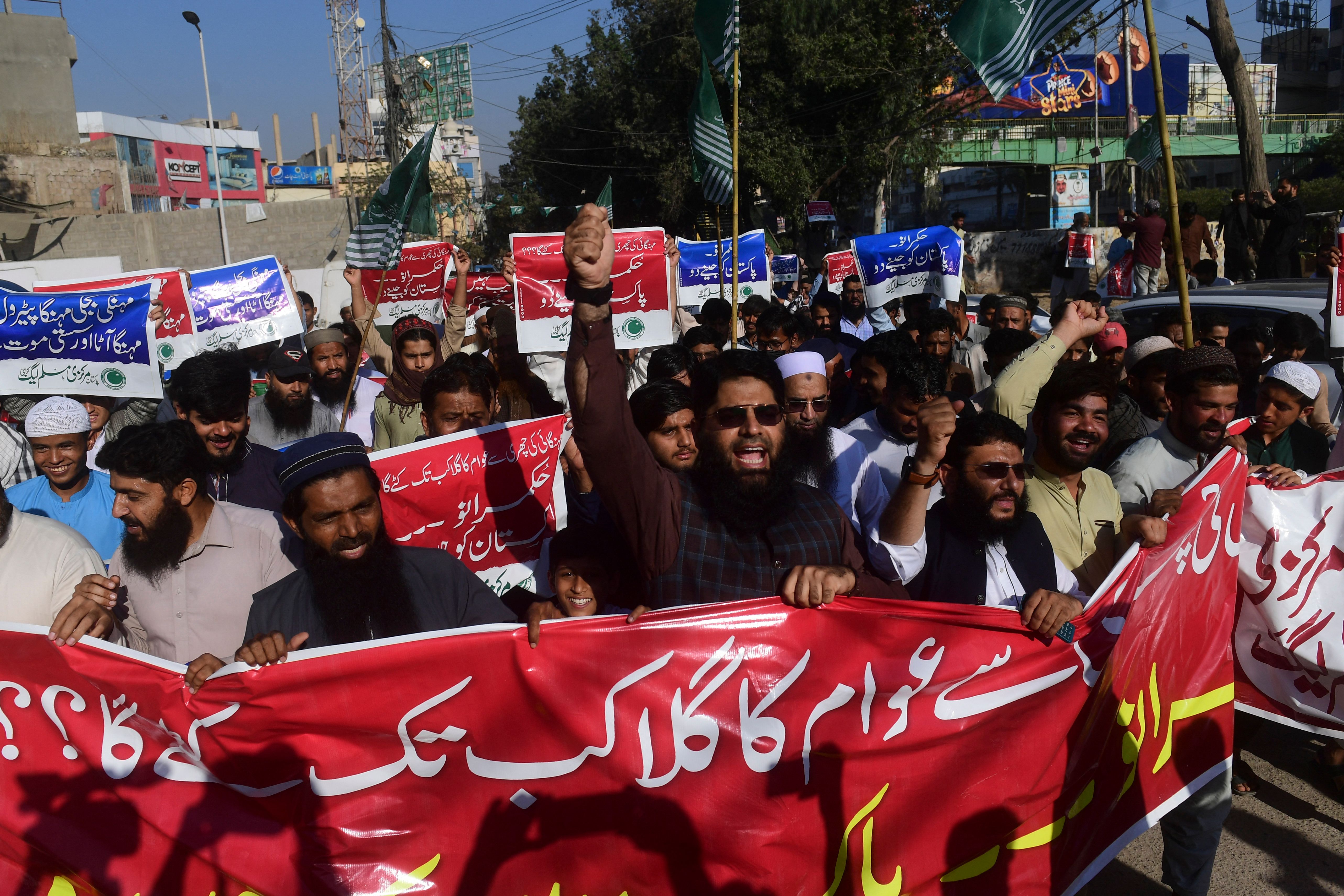 <p>Activists of Pakistan Markazi Muslim League (PMML) carry placards and chant anti-government slogans during a protest against the inflation and price hike in commodity items and oil products, in Karachi on 17 February 2023</p>