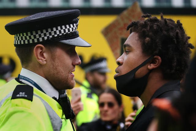 <p>A protester confronts a Police Officer during a Black Lives Matter protest on June 2020 </p>