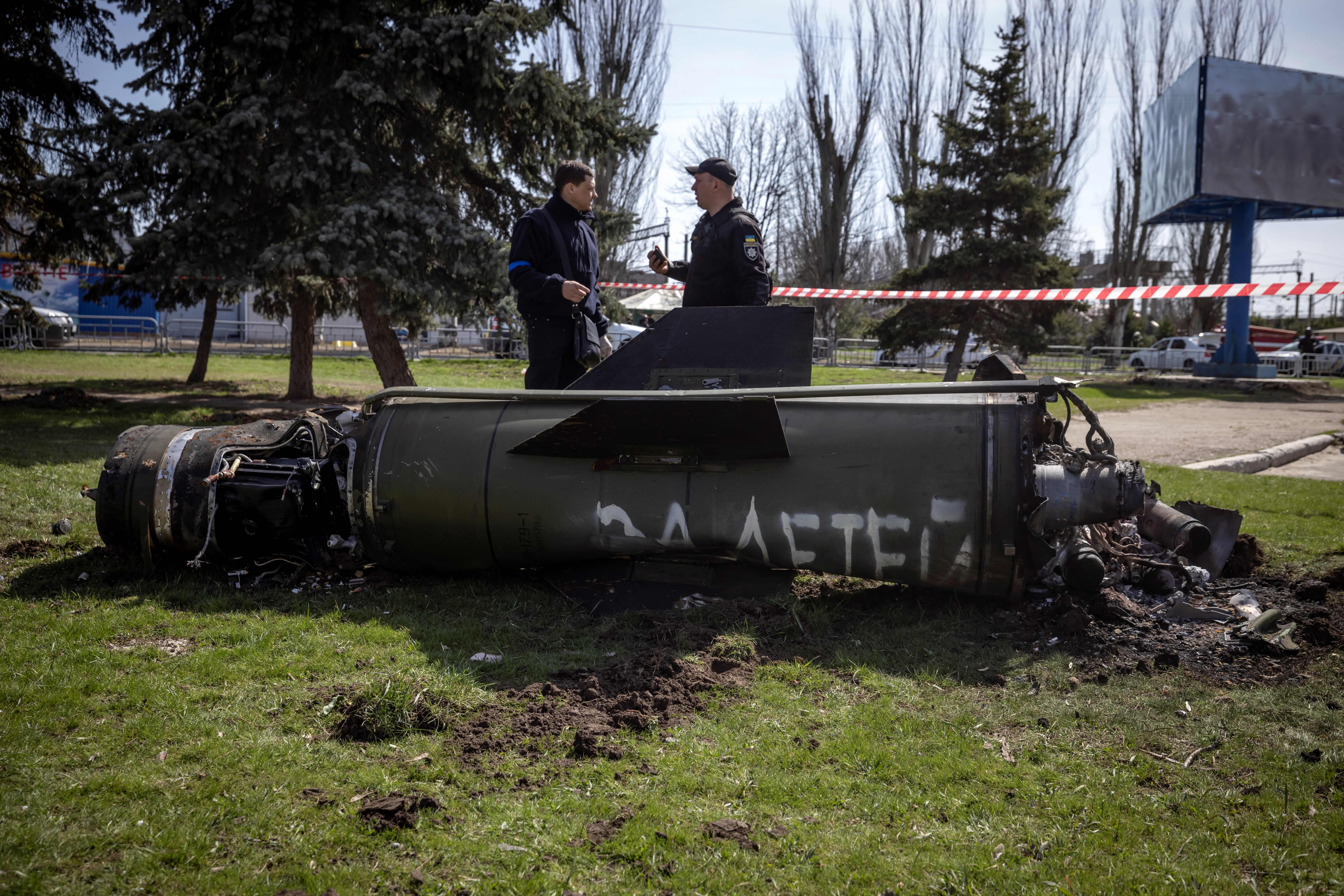 Ukrainian police inspect the remains of a large rocket with the words ‘for [the] children’ in Russian next to the main building of a train station in Kramatorsk, eastern Ukraine