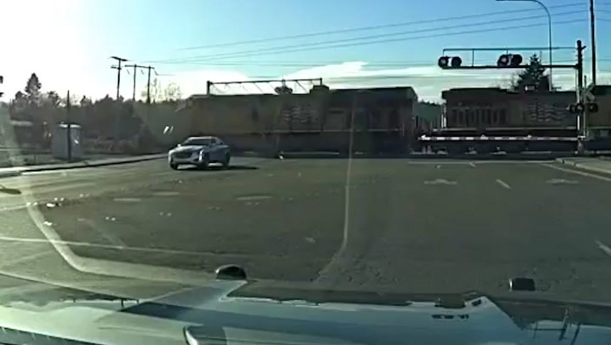 Suspect misses being hit by train by seconds after driving through crossing