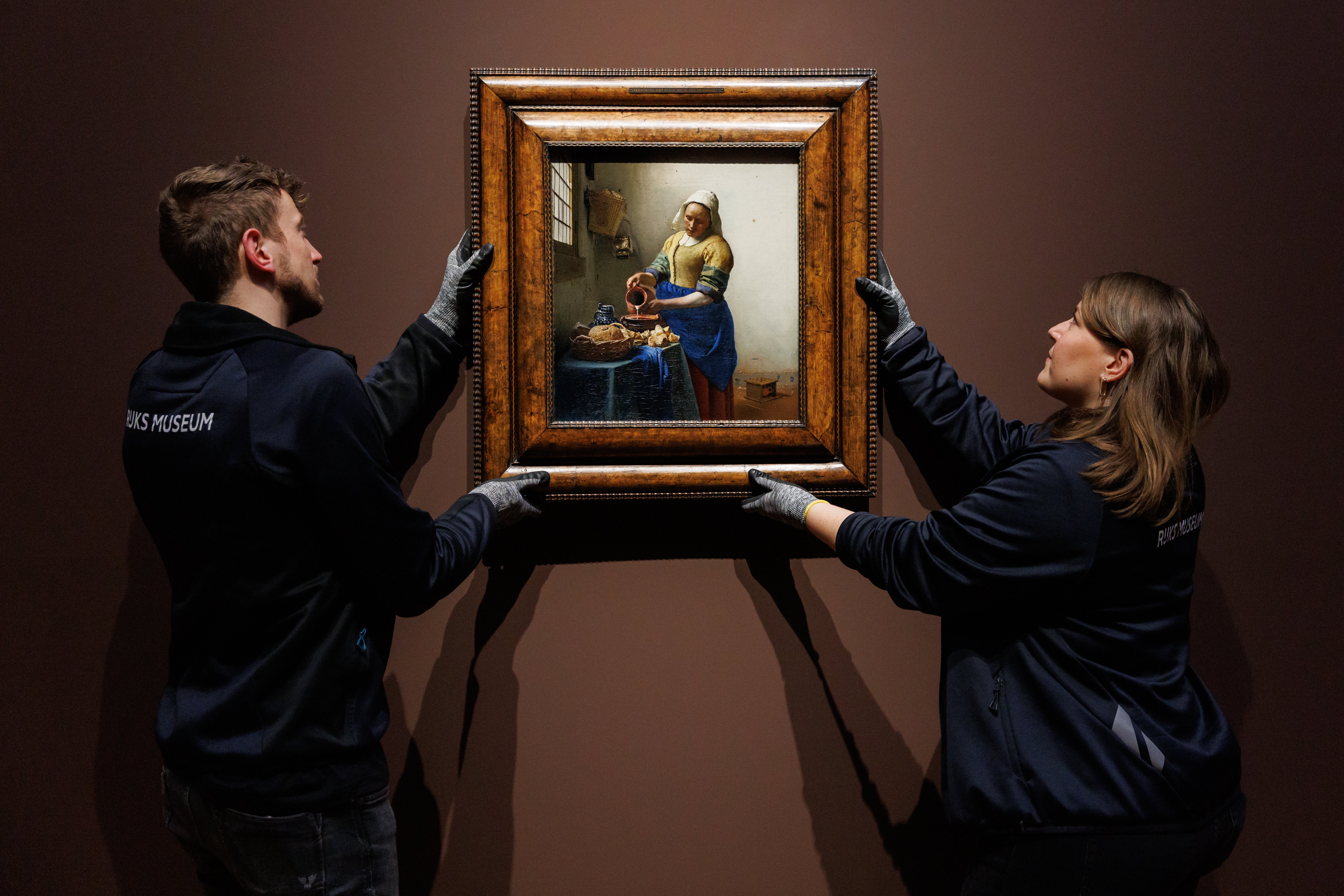 Staff at the museum install Vermeer’s ‘The Milkmaid’