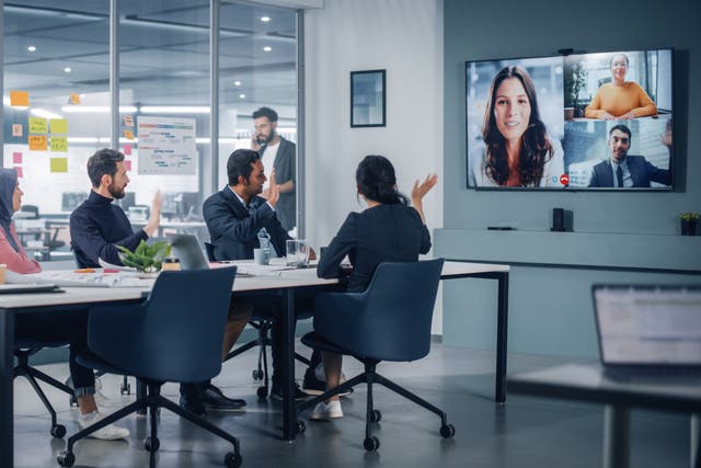 <p>Businesspeople do Video Conference Call with Big Wall TV in Office Meeting Room. Diverse Team of Creative Entrepreneurs at Big Table have Discussion. Specialists work in Digital e-Commerce Startup</p>