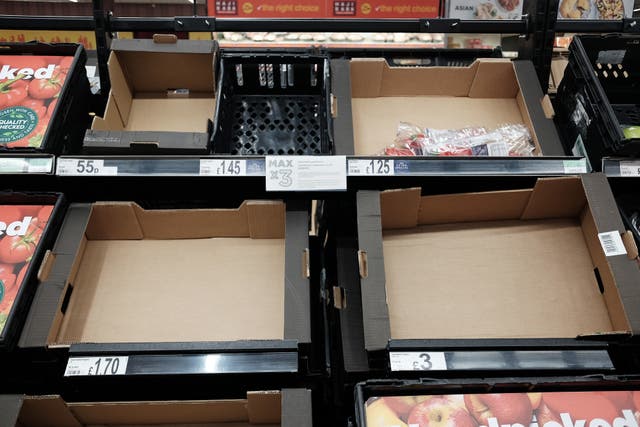 <p> Empty fruit and vegetable shelves at an Asda in east London</p>