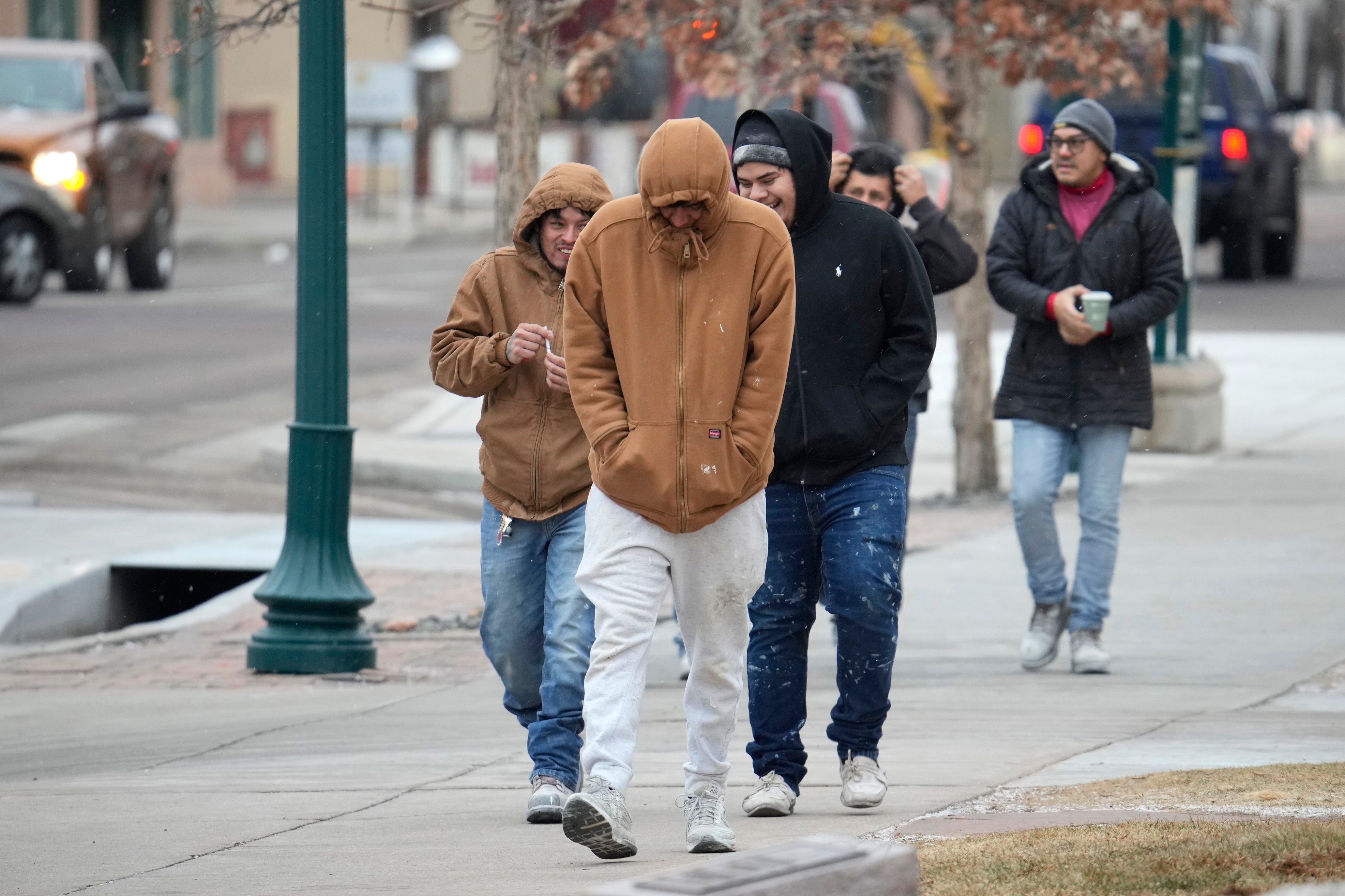 Pedestrians struggle to keep warm while walking along Tejon Street as temperatures hovered in the single digits after a winter storm packing light snow and high winds rolled into the Pikes Peak region on Wednesday Colorado Springs, Colorado (AP Photo/David Zalubowski)