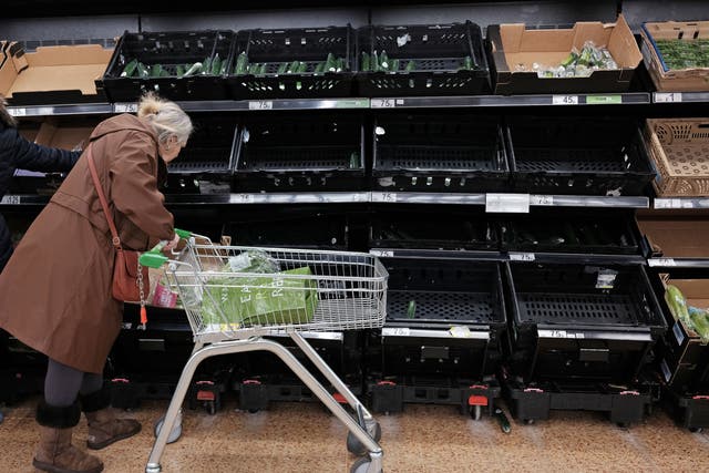 <p>Empty fruit and vegetable shelves at an Asda in east London</p>