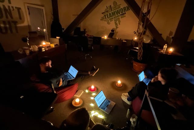 <p>The Kyiv Independent team working by candlelight during a power outage</p>