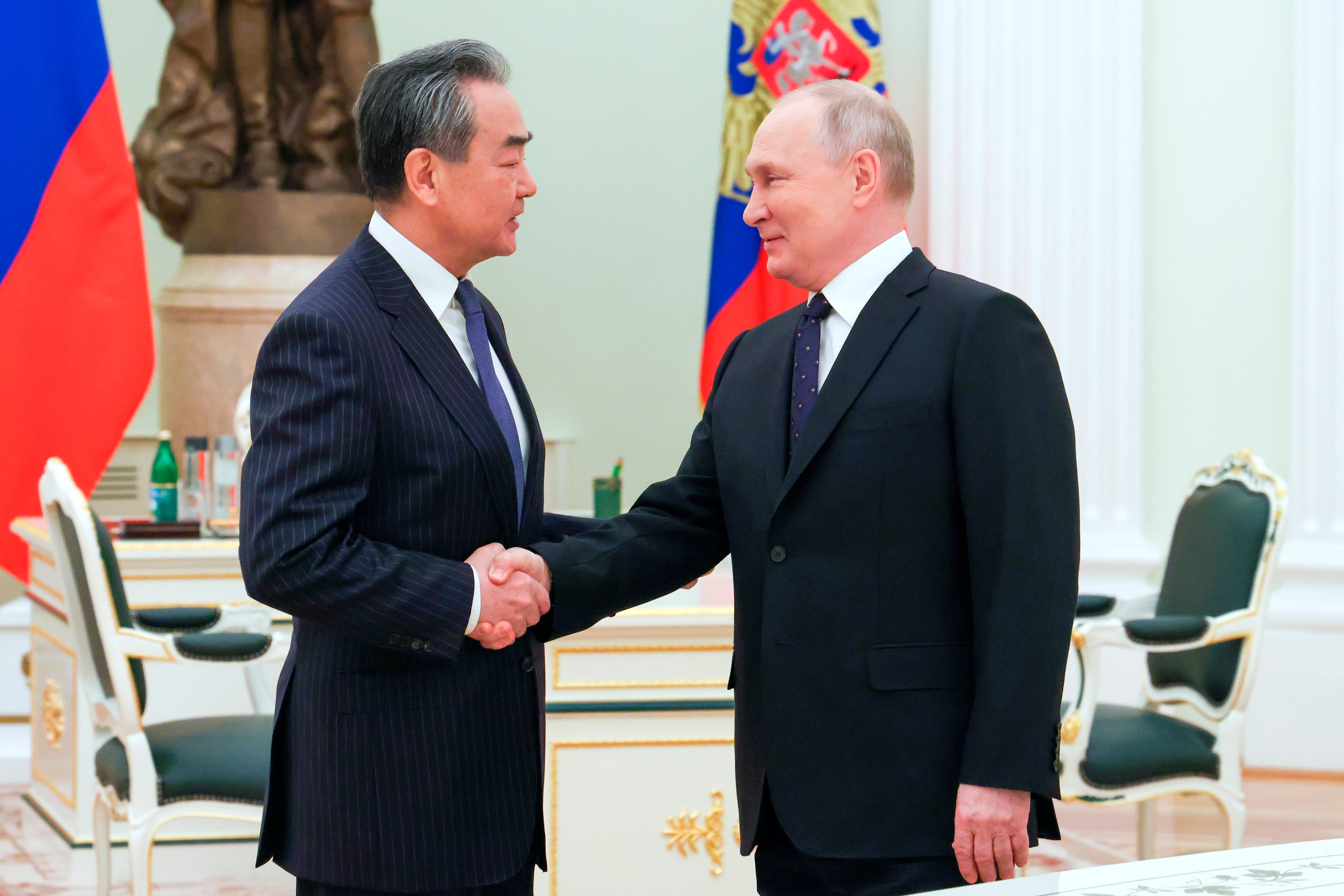 Vladimir Putin greets the Chinese Communist Party’s foreign policy chief Wang Yi at the Kremlin