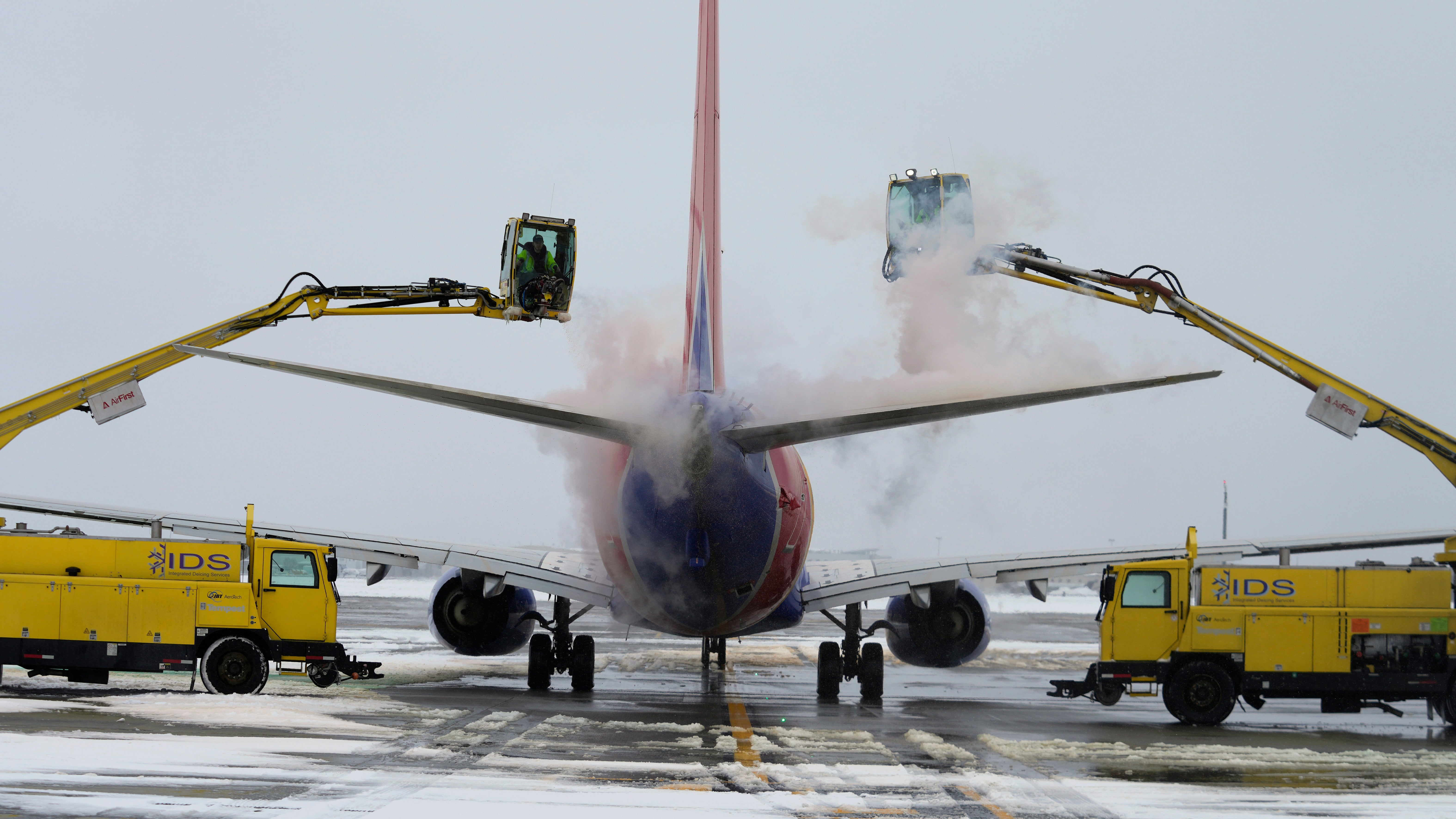 A Southwest Airlines plane is de-iced before takeoff at Salt Lake City International Airport on Wednesday in Utah as temperatures plummeted well below zero during Winter Storm Olive (AP Photo/Rick Bowmer)