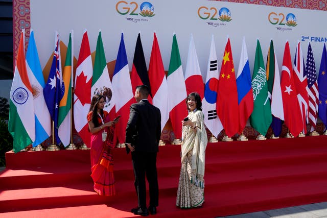 <p>Delegates interact in front of flags of participating countries displayed at the venue of G-20 financial conclave on the outskirts of Bengaluru, India</p>