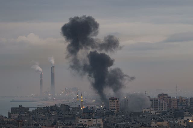 <p>Smoke rises above buildings in Gaza City after Israel launched airstrikes on the Palestinian enclave early on 23 February</p>