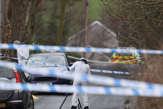 <p>A forensic investigator from the PSNI takes photographs at the scene (Liam McBurney/PA)</p>
