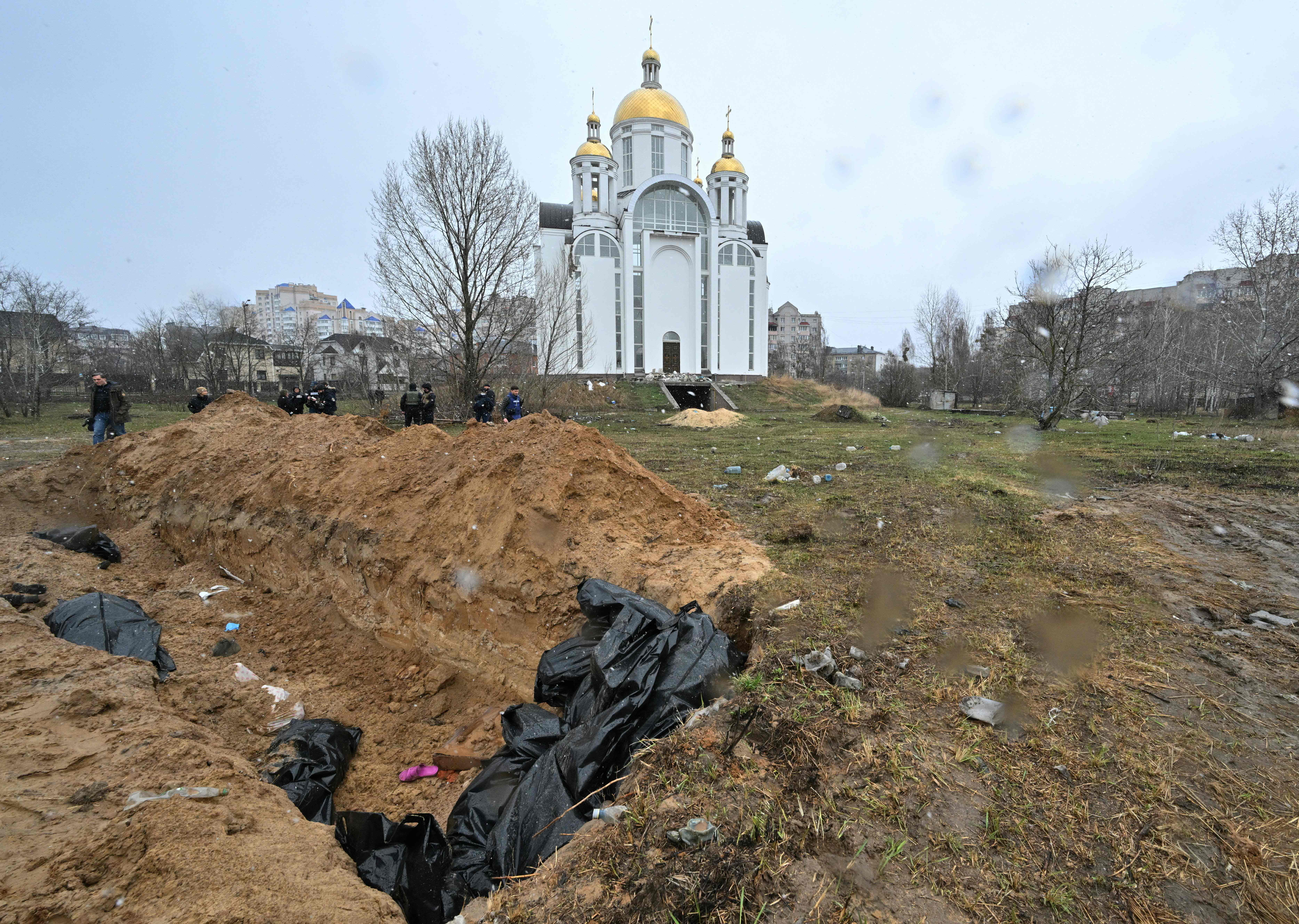 A mass grave is seen behind a church in the town of Bucha outside Kyiv